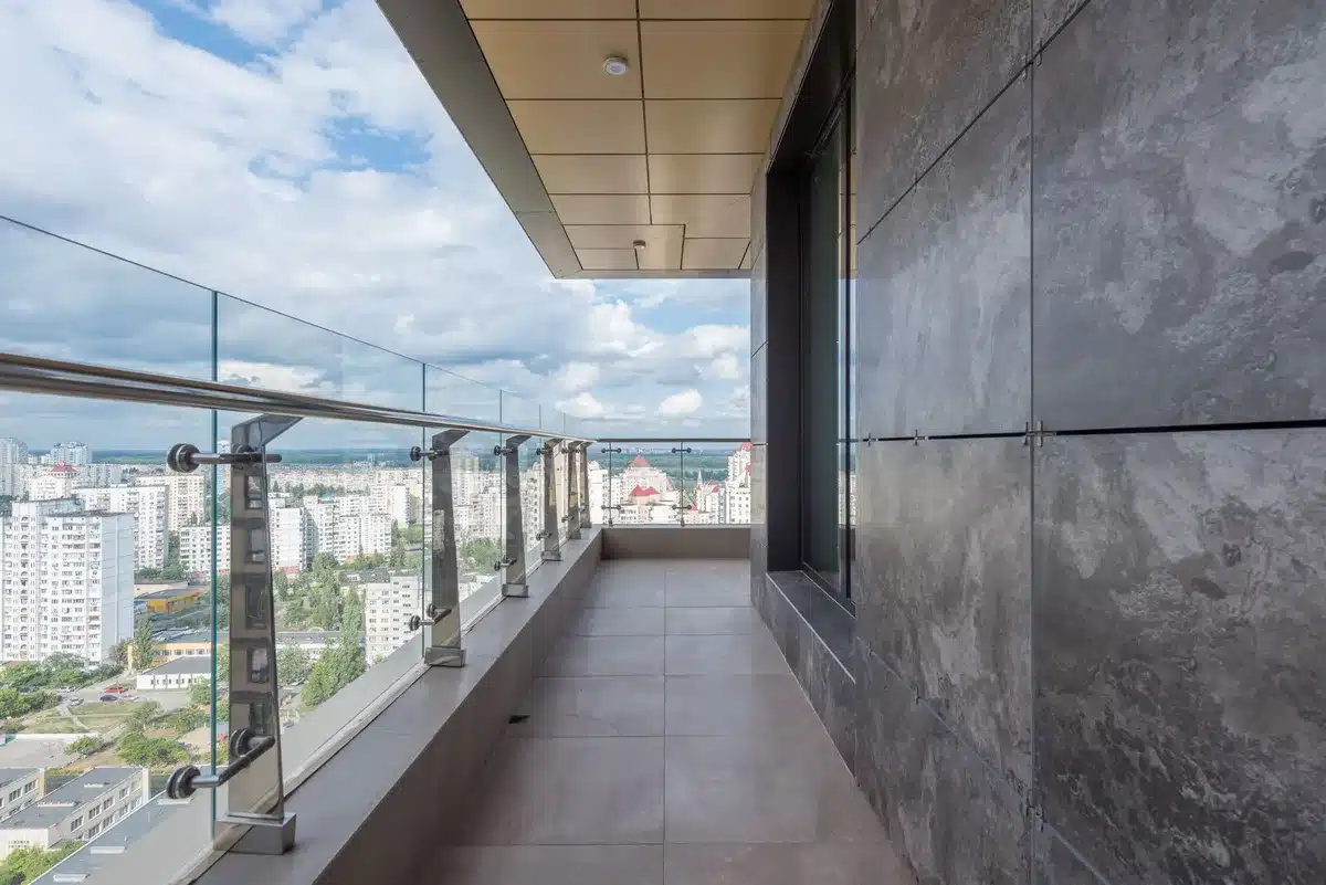 Terrazzo con orto rialzato in acciaio, piante fiorite e fontana, vista sulla città moderna