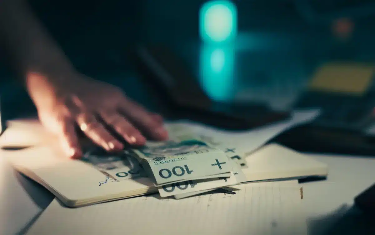Firma di documenti di finanziamento su una scrivania con calcolatrice e penna in un ufficio bancario