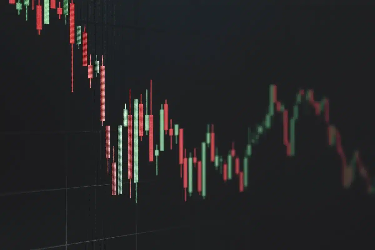Investitore che esamina documenti finanziari e grafici di portafoglio durante un calo di mercato