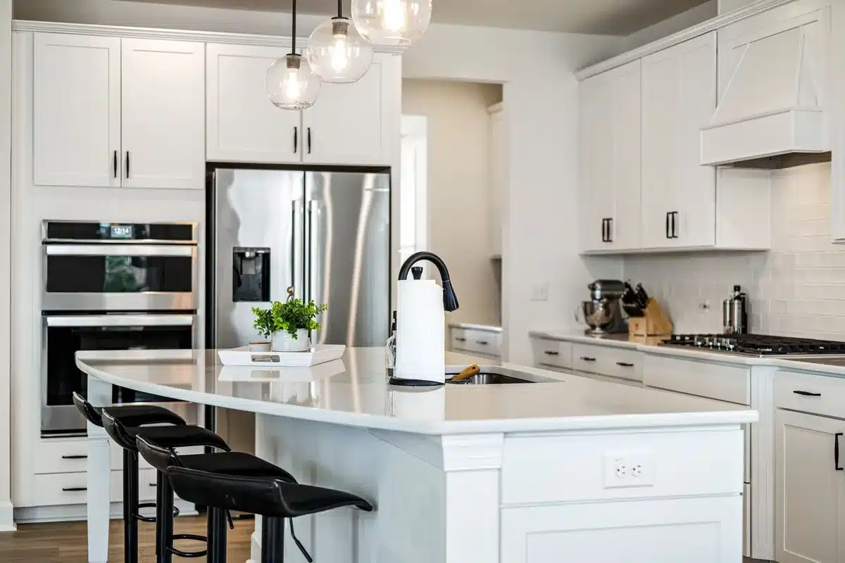 Cucina contemporanea con isola centrale e mobili bianchi, disposizione funzionale dello spazio.