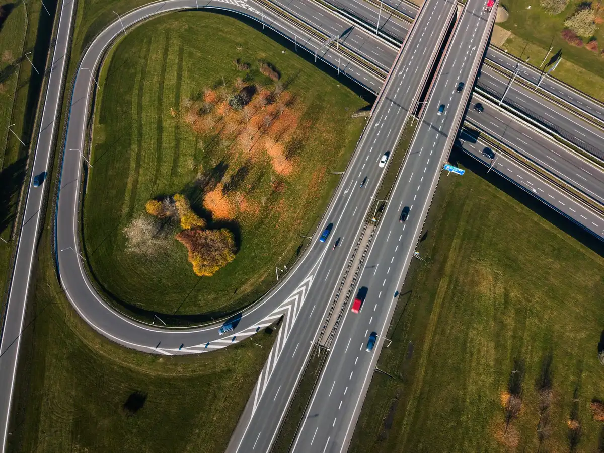 Veduta aerea di un'autostrada con flusso veicolare e stazione di controllo remoto con schermi di monitoraggio