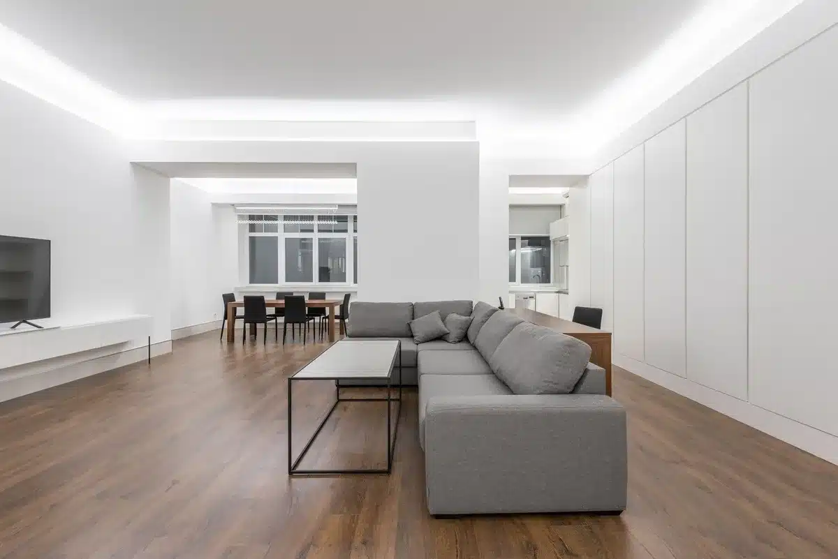 Interno contemporaneo con pareti grigie, dettagli gialli e luce naturale che illumina tessuti e complementi
