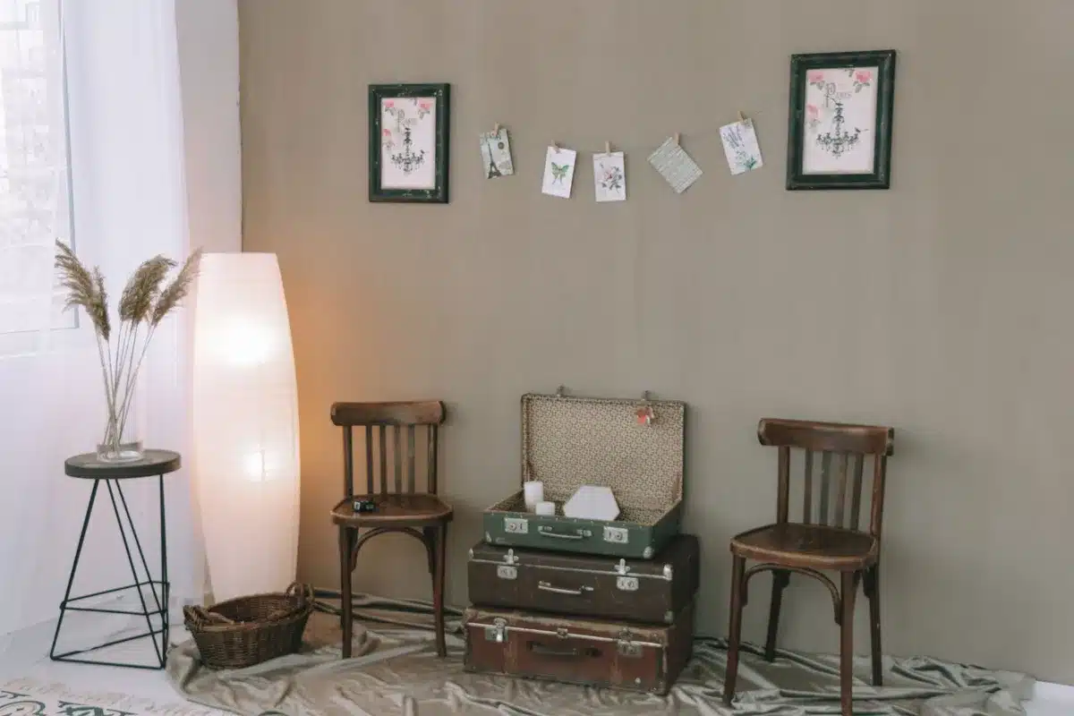 Soggiorno eclettico con arredi vintage e contemporanei, quadri alle pareti e piante in vaso.