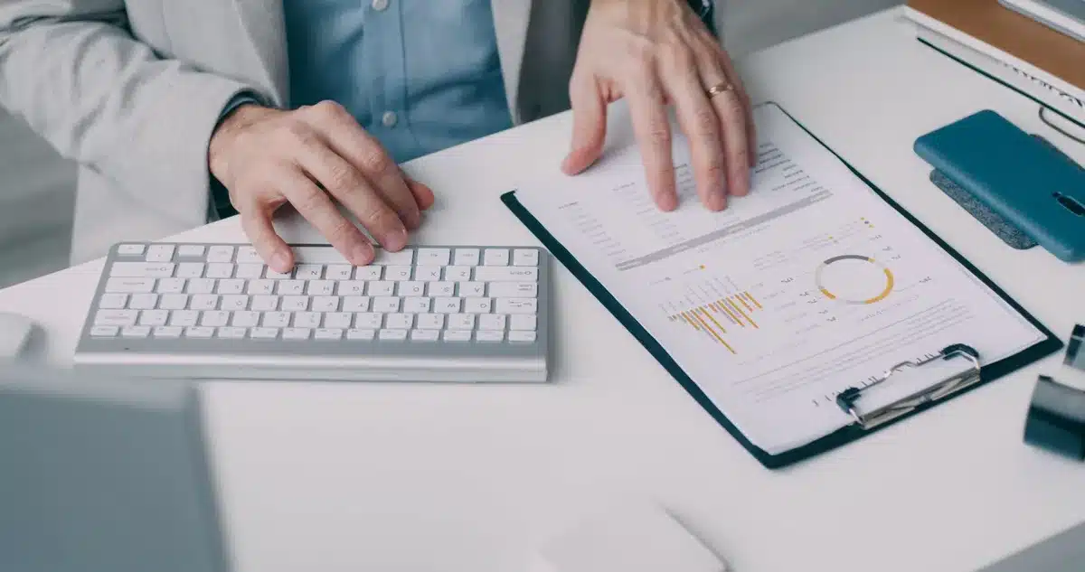Mani che analizzano documenti di valutazione del credito e grafici di dati di mercato su una scrivania