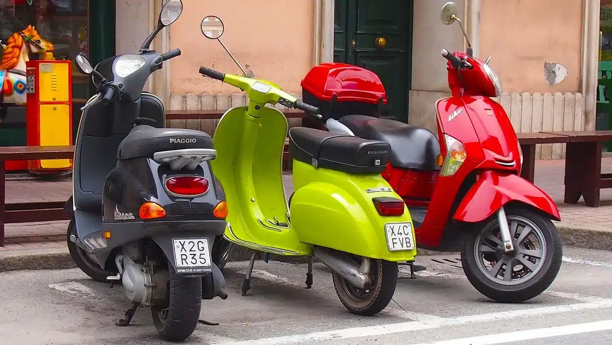 Monopattini e biciclette in sharing parcheggiati vicino a una fermata del tram al crepuscolo