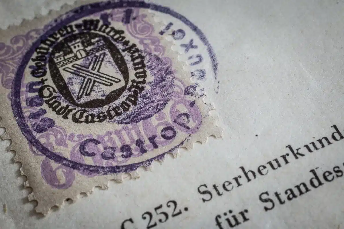 Documento APE su tavolo con planimetrie e una casa in miniatura