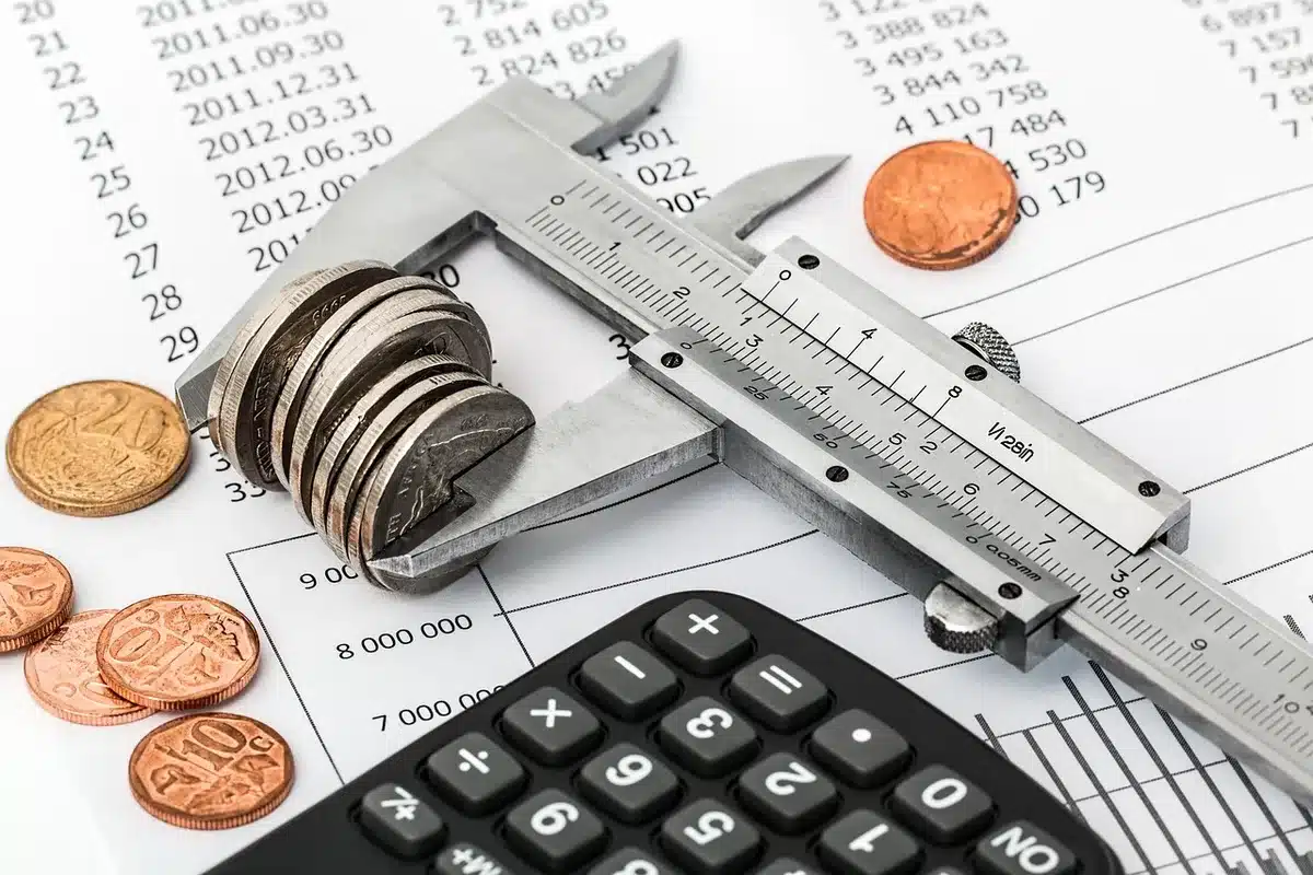 Mani che scorrono documenti fiscali e un calcolatore su una scrivania, suggerendo pianificazione fiscale