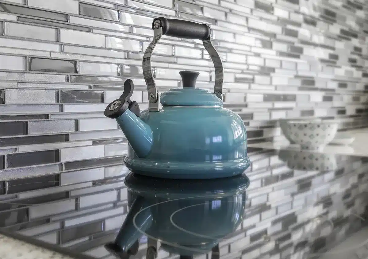 Zona operativa cucina con piastrelle effetto cemento adiacenti al parquet