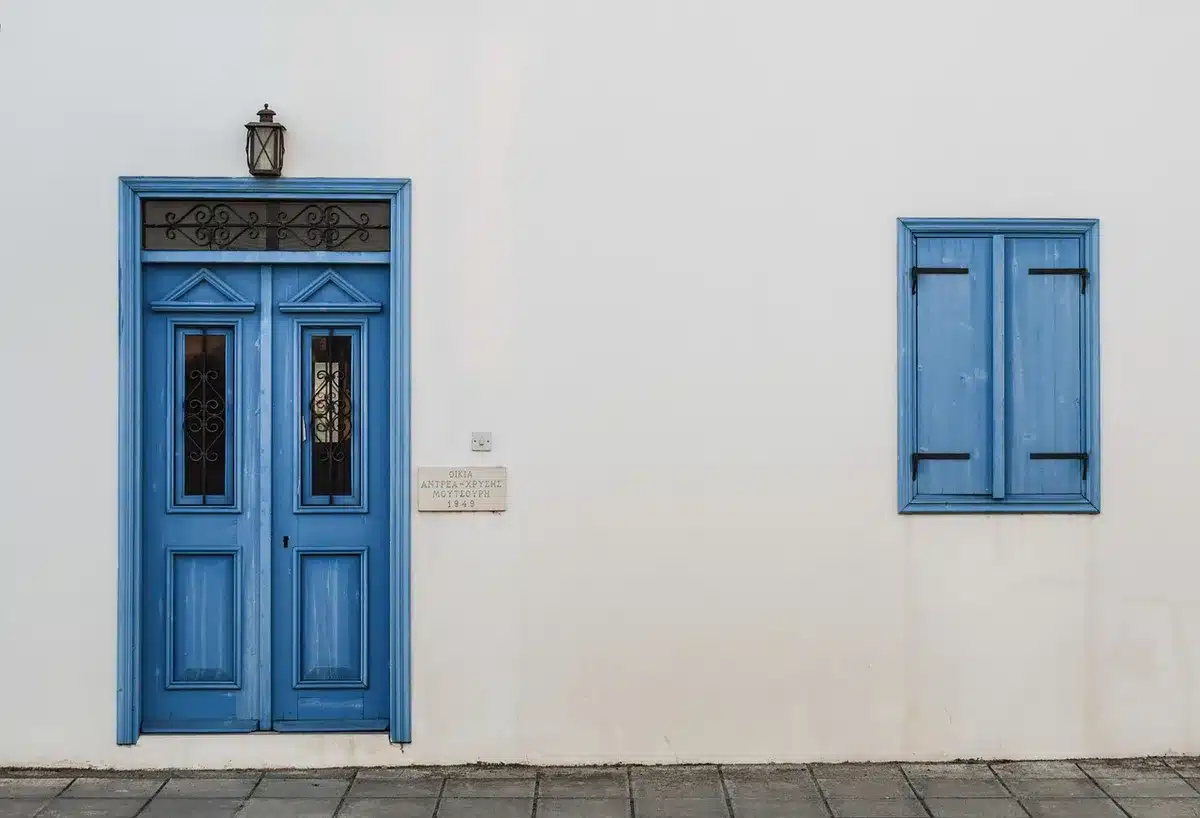 Cucina compatta installata in veranda con infissi scorrevoli e muretto basso