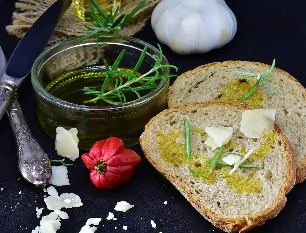Zona giorno con quinta muraria e piano snack, rivestimenti chiari e accenti verde oliva