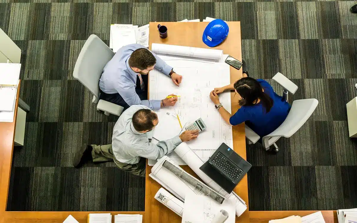 Schermo con dashboard cloud e team che discute strategie digitali